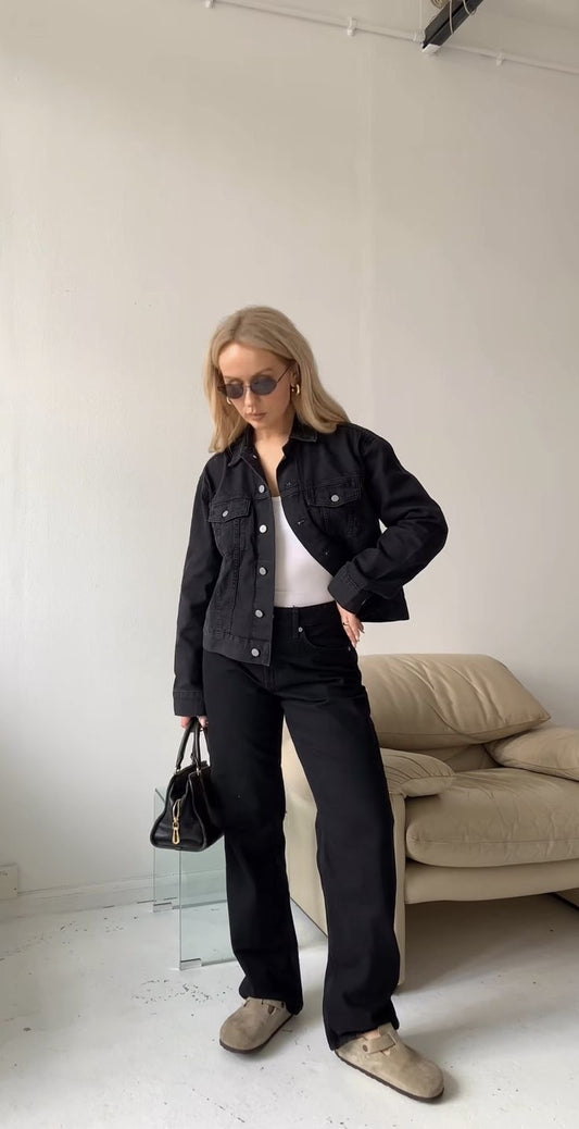 Black denim jacket with black wide leg jeans